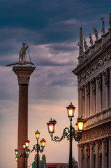 Fototapeta na wymiar Illuminated ornate street lamps in the San Marco Square in Venice, Italy