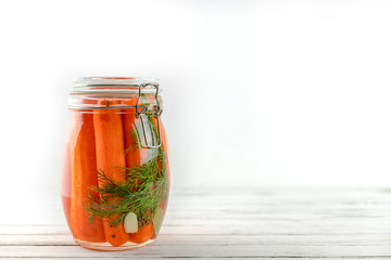 glass jar of fermented carrots. vegetables on a light background. fermentation is a source of probiotics