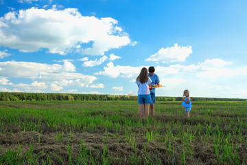Family is flying a kite in a field