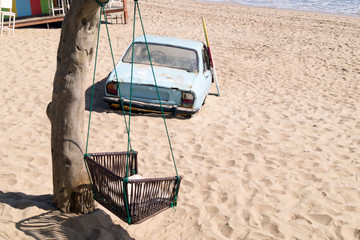 old car buried in the sand on the beach