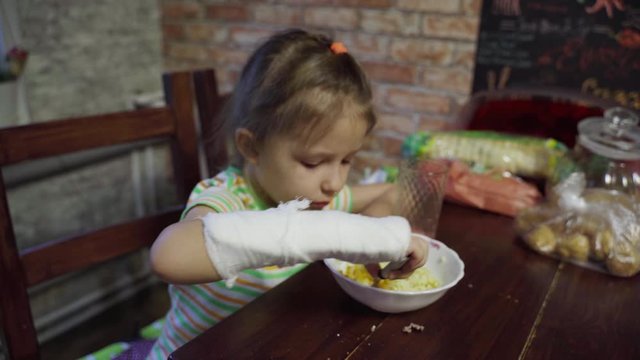 Girl Child With Plasterboard Broken Arm Eats Food Kitchen