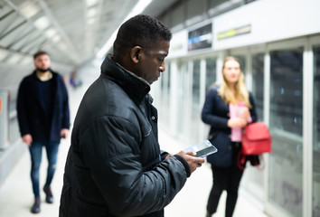 Fototapeta na wymiar African American man with phone at underground station