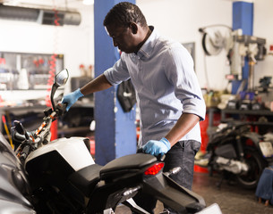 Fototapeta na wymiar Mechanic is repairing modern moto in the workshop