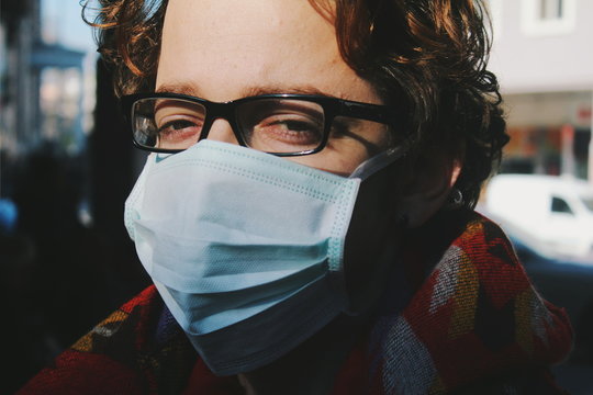 Close up of young man wearing surgical mask outdoors