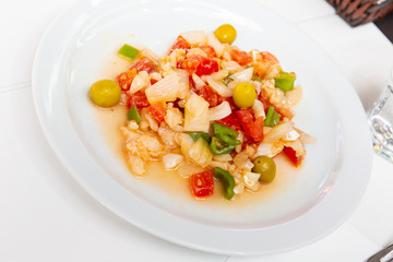 Seafood salad from slices of cod and vegetables