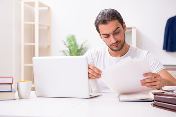 Young male student preparing for exams at home