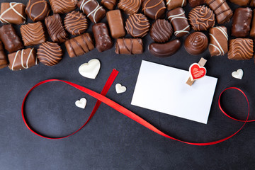 Chocolate pralines with card Valentines day on black background