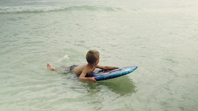 Little boy with surf board having fun in the ocean. Panama City Beach USA