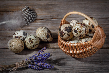 Obraz premium Quail eggs on a wooden background in a basket