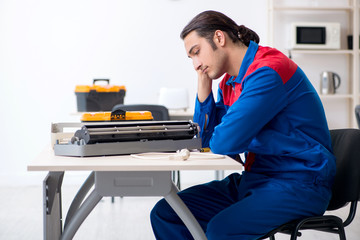 Young repairman repairing air-conditioner at warranty center