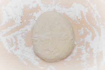 Prepared kneaded dough on a wooden table at home