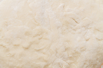 Prepared kneaded dough on a wooden table at home