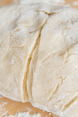 Prepared kneaded dough on a wooden table at home