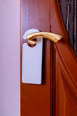 Do not disturb sign at the door. Empty label or flyer on a door handle for your text.