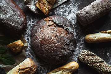 Different types of bread on black background