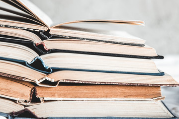 Opened books in a stack on a light home background. Education, hobbies