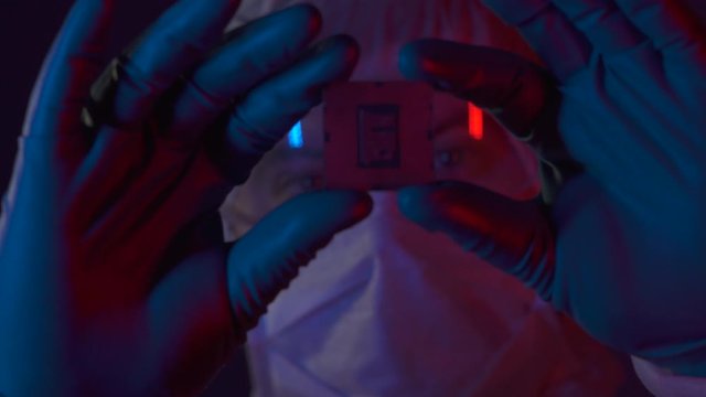 Scientist completed a scientific experiment in electronics. Silicon electronic chip in the hands of a researcher in lablaboratory. Engineer testing experimental innovation in cyber technology industry