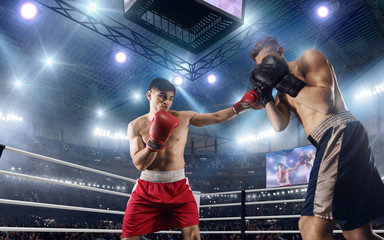 Fototapeta na wymiar Two boxers are fighting on professional boxing ring.