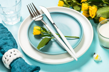 Spring table setting with flower on blue.