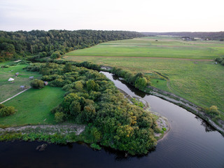 A beautiful sunny view of the forest, fields and river from above. Summer drone photography 