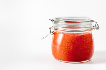 Hot chili pepper sauce paste harissa. Adjika. Traditional Tunisia, Georgian and Arabic cuisine. Homemade rose harissa in a glass jar.