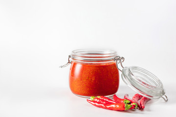Hot chili pepper sauce paste harissa. Adjika. Traditional Tunisia, Georgian and Arabic cuisine. Homemade rose harissa in a glass jar.