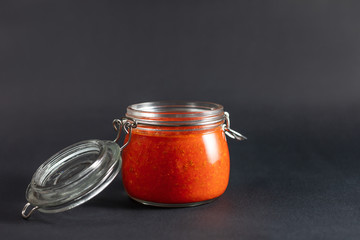 Hot chili pepper sauce paste harissa. Adjika. Traditional Tunisia, Georgian and Arabic cuisine. Homemade rose harissa in a glass jar.