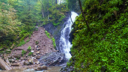 Fototapeta na wymiar Zhenezhsky Hook waterfall in the Ukrainian Carpathians near the villages of Mykulychyn and Tatariv.