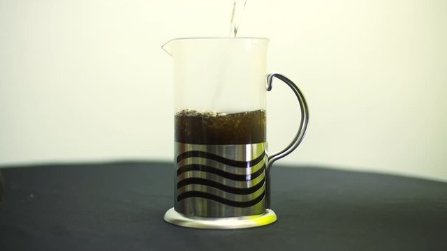 Zalewanie czarnej herbaty wrzątkiem w dzbanku 
