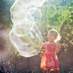 little girl playing with soap bubbles