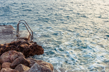 Fototapeta na wymiar Escalera de piscina en cala de roca. Mallorca (España)