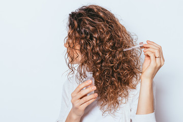 Female's hands using cosmetic serum to prevent split ends