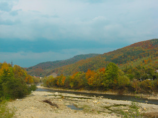 Obraz premium Beautiful views of the mountain river in the autumn. All the colors of the golden autumn.