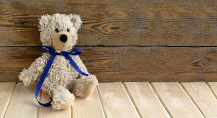 Cute teddy bear alone sitting on wooden background. Universal  concept for child health care, friendship or life style. Banner. Copyspace.