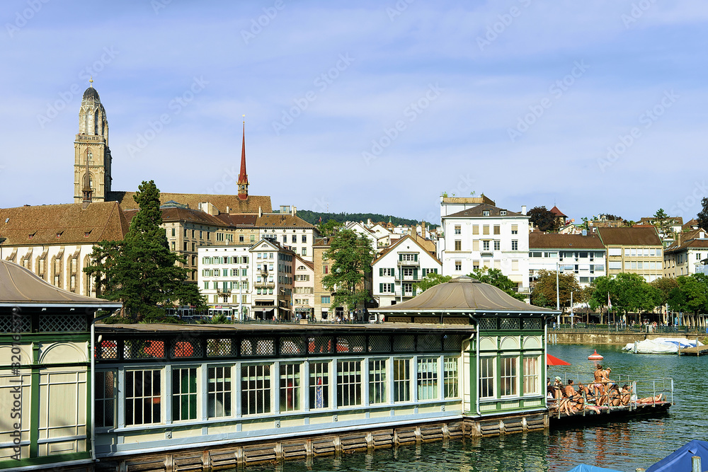 Poster zurich, switzerland - september 2, 2016: women beach at limmatquai and grossmunster church in zurich