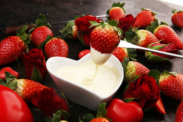 Valentine Chocolate fondue melted with fresh strawberries and dark and white chocolate. Red roses...