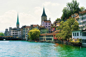 Zurich, Switzerland - September 2, 2016: Limmat River quay and Saint Peter Church and Fraumunster Church in the city center of Zurich, in Switzerland.