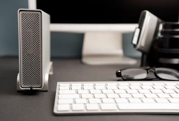 concept work table photographer, composition, silver-colored desktop hard drive with spectacles, 80mm photographic lens, compacflash cards downloader, , partial computer view, black badground 