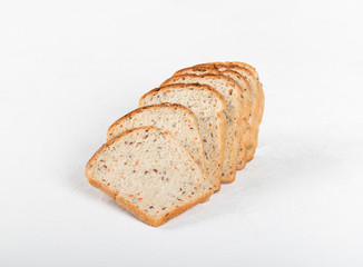 Whole grain fitness bread with dried carrots and flax, pumpkin, and sunflower seeds, sliced on a light background