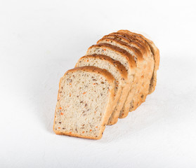 Whole grain fitness bread with dried carrots and flax, pumpkin, and sunflower seeds, sliced on a light background