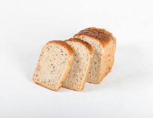 Whole grain fitness bread with dried carrots and flax, pumpkin, and sunflower seeds, sliced on a light background