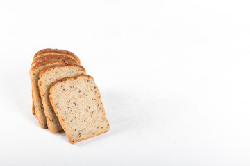 Whole grain fitness bread with dried carrots and flax, pumpkin, and sunflower seeds, sliced on a light background