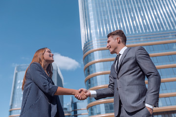 handshake of young business people on the background of an office building.