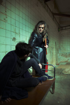 Evil kidnapper holding and controlling young man in horror place