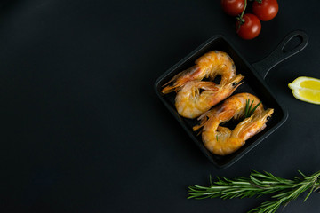 Grilled shrimps with lemon and rosemary on frying pan