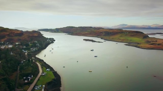Flying out over Oban Bay in Scotland with boats in the harbor. 
4K 29fps