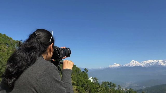 Indian Female photographer, explorer capturing the Himalayan range  through the lens, in slow motion and steady cam in Uttarakhand in northern India