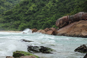 Fototapeta na wymiar Trindade, Paraty/Rio de Janeiro/Brazil - 01-19-2020: Praia do Meio beach. Strong waves, dangerous sea, drowning risk, sorrounded by many rocks