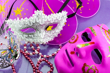 A festive,Beautiful white mardi gras or carnival mask on beautiful purple paper background.