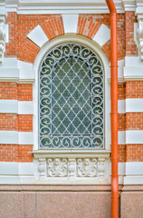 Close-up of ancient vintage arch window with cast iron white lattice, pattern